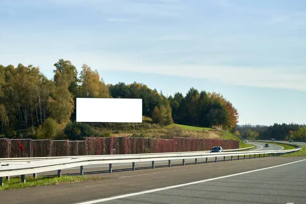 A highway billboard with a white screen for outdoor advertising. The photo illustrates an outdoor advertising poster on the highway with a blank billboard. billboard has a white screen
