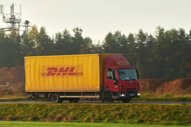 24.10.2023 Polonya, Avrupa. DHL Teslimat. Sevkiyat ve paket teslimatı. Sarı DHL kamyonu iş başında.