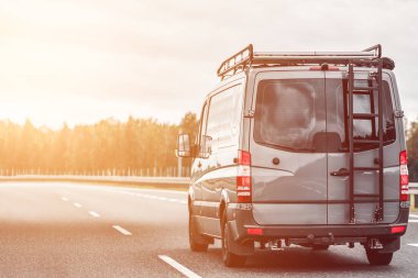 Kamu yolunda bir karavan. Offroad modern minibüs. Arkasında merdiven, üstünde de bagaj tavan rafı var. Yolculuk ve macera kavramı.