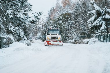 Bir kar küreme kamyonu kış fırtınası sırasında karayolunu kardan temizler. Buz gibi yolu temizlemeye yarayan bir kamyon gibi kar küreme makinesinden fırlıyor. Kış boyunca yollar ve altyapı bakımı.