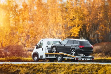 Tow truck and car on the road. A vehicle breakdown and collision leads to a tow truck delivery and insurance service. Roadside assistance for a car accident. clipart