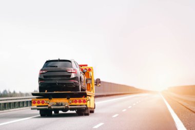Bir çekicinin yolda bozuk bir arabası var. Çekici kamyon otoyolda bir araba taşıyor. Araba servisi taşıma konsepti. Yol kenarı Kurtarma.