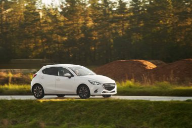 Otoyolda ilerleyen modern hatchback 'in yan görüntüsü.