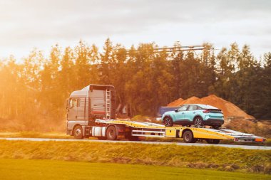 Geri çekilen bir kamyon, bozuk bir arabayı halka açık yolda taşıyor. Yolculuk sırasında araba arızası. Yol yardımı devrede..