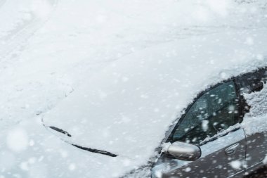 Kış Fırtınası 'nda kar taneleriyle kaplı donmuş bir araba ön camı. Kış kırsalında buzlu ve kar taneli bir arabanın ön camının yakın çekimi.