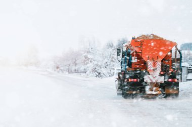 Tuz ve kum ayırıcılı traktör, yol bakımı - kışın kumsal aracı. Belediye hizmetleri sokaklarda buz ve kar eritiyor. Halka açık yollarda tuz karışımı dağıtmak.