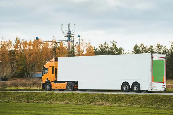 Driving a sustainable cargo truck with enhanced aerodynamics and additional load capacity on a highway under a golden sky. eco-friendly shipping. sustainable and efficient freight transport