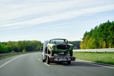 Geri çekilen bir kamyon, bozuk bir arabayı halka açık yolda taşıyor. Yolculuk sırasında araba arızası. Yol yardımı devrede..