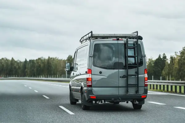 A van with a roofrack and a ladder ready for a road trip in nature. Concept of traveling with a van and enjoing the outdoor adventures. The ultimate van camping in Europe