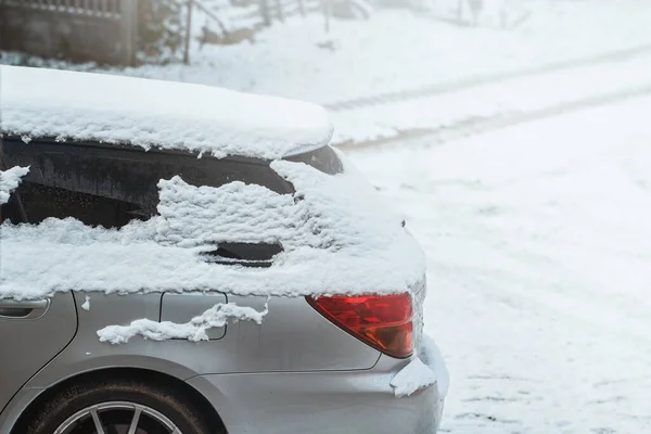 A Touring Car Covered with Snow and Ice Parked on a Winter Street. How to Deal with a Frozen and Snowy Car Window in a Winter Day