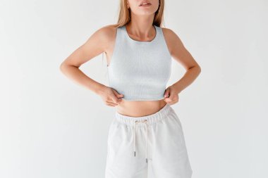 Modern Moda Trendleri. Yüzü olmayan kadın beyaz bir bluz ve beyaz şort giyiyor. Çağdaş Beyaz Üstlü Kadın Moda. Tarz sahibi beyaz bluz giyen bir kadın etekle eşleşiyor.