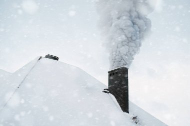 Kışın ısıtma evi. Kış mevsiminde modern bir evin bacasından koyu duman çıkar. Çevre kirliliği. Ahşap ve kömür gibi katı yakıtlarla ısınma CO2 gazı üretir.