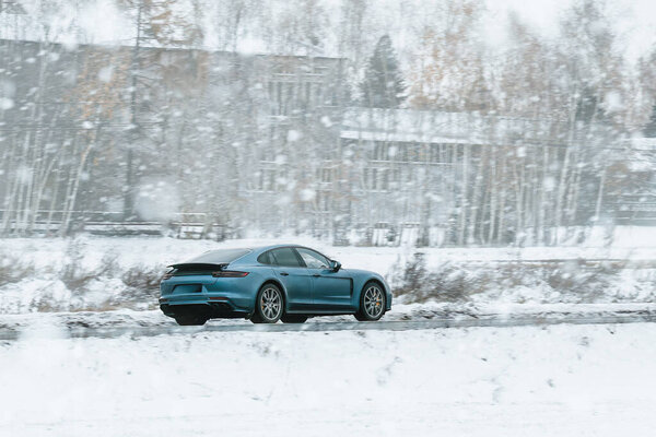 German sports car on a snowy highway. Dangerous driving with a performance car during winter