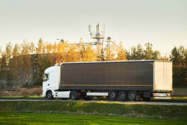 Kargo taşımacılığı yarı karavan kamyonuyla yolda. Kamyonlar teslimat ve nakliye için konteynırlar dolusu mal taşıyorlar. Dünya çapında yayılan sürdürülebilir bir tedarik zincirine bağlılar..