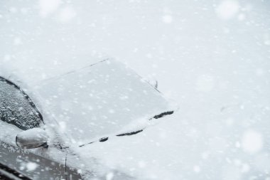 Kış Sürüşü İpuçları: Kazıyıcıyla araba ön camından nasıl buz ve kar temizlenir. Arabanın dışı taze karla kaplı. Yolculuktan önce arabayı ısıtıyorum. Oyalanan motor