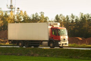Mal teslimatı ve nakliyesi yarı karavan kamyonlarıyla. Kamyonlar kargo konteynırlarıyla yolda ilerliyorlar. Küresel pazara yönelik ürünlerin ihracatı ve ithalatında yer alıyorlar..