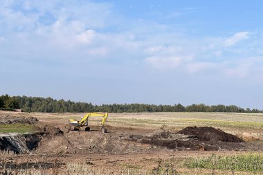 Şehir şantiyesinde büyük bir kazıcının yakın çekimi. İnşaat alanında modern inşaat makineleri. İzole kepçe yakın çekim. Yol yapımı. Mimarlık, mühendislik..