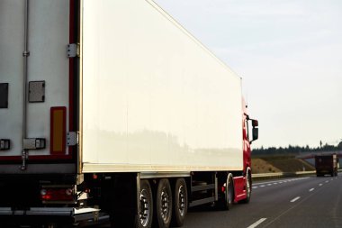 Mal teslimatı ve nakliyesi yarı karavan kamyonlarıyla. Kamyonlar kargo konteynırlarıyla yolda ilerliyorlar. Küresel pazara yönelik ürünlerin ihracatı ve ithalatında yer alıyorlar..
