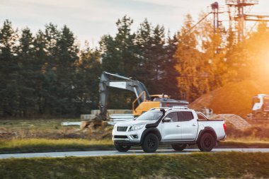 Crew cab truck offroad driving at the construction site. Capable transport for engineers and workers on site.
