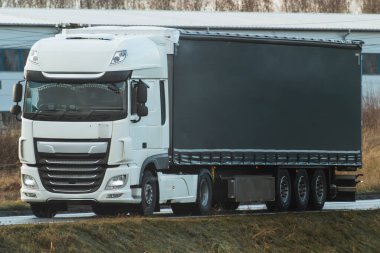A truck transports cargo containers transported on land with semi trailers. Highway shipping and post delivery. Global commerce and industry that uses sustainable efficient logistics systems.