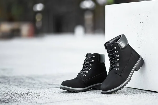 A pair of stylish dark brown leather boots paired with grey denim jeans captures the essence of modern urban fashion.