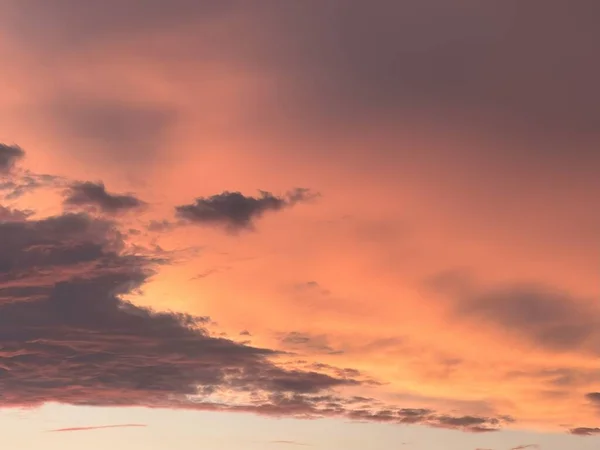 The Dance of Dusk as Clouds Embrace the Warm Glow of a Setting Sun. Beautiful clouds in the sky background. A Symphony of Sunset Colors Painting the Evening Sky with Hues of Orange and Pink