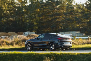 Çapraz bir SUV gibi maceralı bir sürüş güzel güneş ışığı altında bir otoyol boyunca hızlanır ve doğa güzelliği ile çevrilidir..