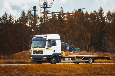 Araba Taşıyıcı Çekici Tırı Yüklü Aracı Olmadan Süratle Yolda Sürüyor. Yaz Peyzajında Otoyolda Metin İçin Boşluğu olan Modern ve Yeni Çekici Taşıyıcı