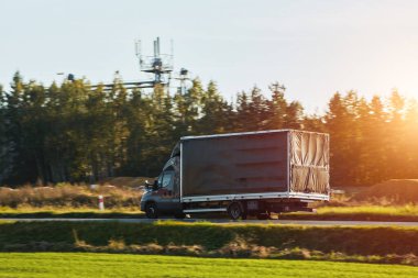 Modern white trucks with semi-trailers drive on a highway. Transporting cargo containers for commercial and industrial purposes. Sustainable logistics and efficient delivery methods to ship goods.