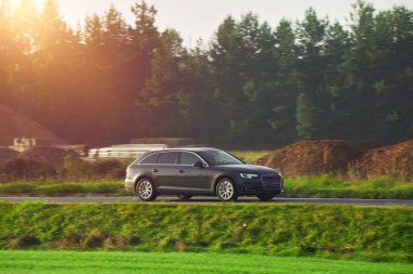 Melez bir steyşın araç otoyolda hızla ilerliyor. Ailesi olan modern ve güvenli bir araba günbatımının büyüleyici ışığında sürdürülebilir ve modern bir seyahatin tadını çıkarır..