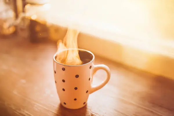 A steaming cup of coffee bathed in the soft glow of morning light brings warmth and comfort to start the day. Golden sunlight illuminates a polka-dotted mug filled with hot beverage.