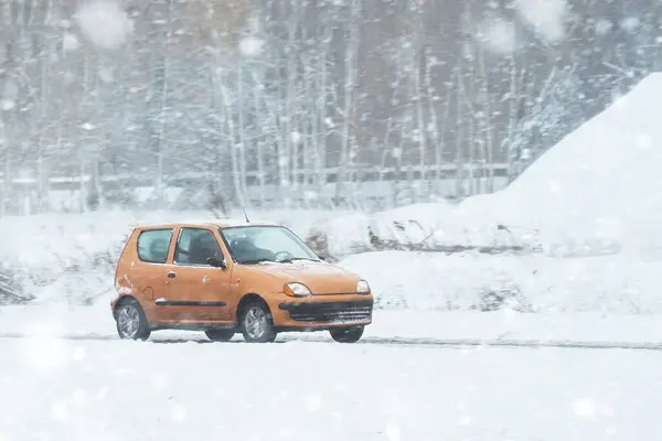 A car driving on a slippery highway in winter. Car on a snow-covered road with a lot of ice. The car has winter tyres. Winter time driving. Winter holidays with the family.