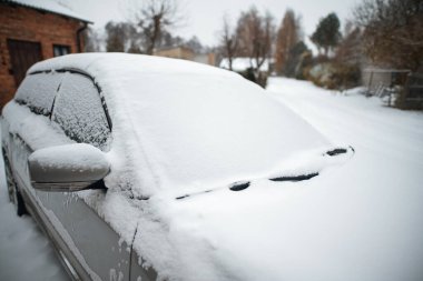 Kış Fırtınası 'nda kar taneleriyle kaplı donmuş bir araba ön camı. Kış kırsalında buzlu ve kar taneli bir arabanın ön camının yakın çekimi.