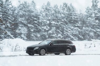 Kışın kaygan bir otoyolda giden bir araba. Karla kaplı bir yolda bir sürü buzla dolu bir araba. Arabanın kış lastikleri var. Kış zamanı sürüş. Aileyle kış tatili.