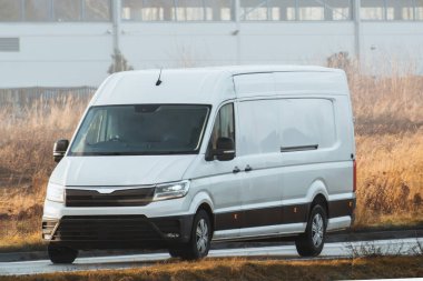 Ticari minibüs yolda. Teslimat minibüsünün yakın çekim modeli izole edildi. Son varış yeri nakliye kamyonu modeli. Kapıdan kapıya iş ve müşteri teslimatı.