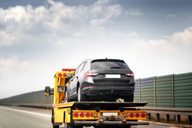 Otobanda bir araba kazası bir çekicinin gelişine yol açar. Taşıyıcı hurdaya dönmüş arabayı alıp götürüyor. Gökyüzü bulutlu ve trafik yavaş.