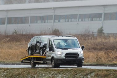 Çekici iş yerinde. Uçsuz bucaksız gökyüzünün altında, açık bir yolda bir araba arızasının sessiz hikayesi yatıyor ve yardım tam zamanında geliyor..