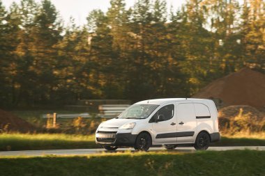 Karayolunda ticari bir kamyonet, hızlı ve güvenilir nakliye araçları kullanarak ülkenin dört bir yanına mal ve ürün taşıyor..