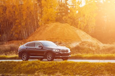 Şık ve hızlı bir Alman lüks arabası gün batımında manzaralı güzel bir yolda sürdürülebilir bir seyahat deneyimi yaşamaktadır..