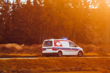 Uzakta Binalar ve Ağaçlar ile Wintry Yolu boyunca Acil Durum Araç Hızları