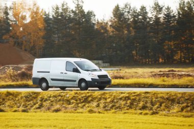 Kendi dağıtım servisini bu beyaz minibüsün maketi ile tasarla. İş logonuz ve isminizle kişiselleştirmeniz için boş bir paket. Farklı manzaralı bir ticari araç yolda izole edilmiş..