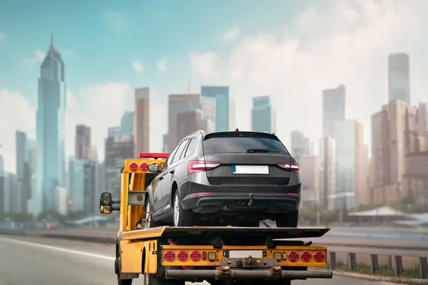 A tow truck with a flatbed is ready to assist you in case of a vehicle breakdown or accident on the highway and urban city streets. Car accident and towing assistance insurance.