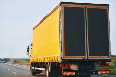 Side view of truck with semitrailer shipping goods on the highway. Sustainable future global supply chain. Export and import in the EU economic zone. Logistics and shipping concept.