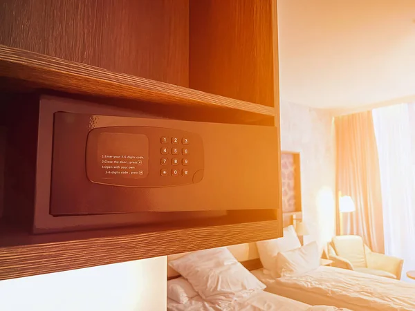 Small digital safe on a shelf in the closet. Safe at home or hotel. Open safe in a wealthy house. Safety box in a hotel room. Concept of safe storage for money, jewelry and documents