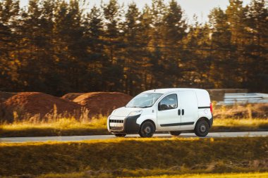 Kendi dağıtım servisini bu beyaz minibüsün maketi ile tasarla. İş logonuz ve isminizle kişiselleştirmeniz için boş bir paket. Farklı manzaralı bir ticari araç yolda izole edilmiş..