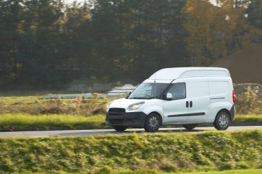 Özelleştirmen için boş ambalajı olan beyaz bir minibüsün maketi. Teslimat ve ulaşım hizmetiniz için ticari bir araç. Yolda izole edilmiş küçük beyaz bir kamyon var..