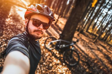Güneş gözlüklü ve Kasklı Sportif ve Maceraperest Adam Bisikletli Kendi Fotoğrafını Çekiyor