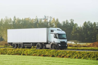 A truck transports cargo containers transported on land with semi trailers. Highway shipping and post delivery. Global commerce and industry that uses sustainable efficient logistics systems.