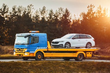 Bir çekici kötü havada otoyolda bozuk bir araba taşır. Yol yardımı, başı dertte olan bir sürücüye yardım eder. Geri çekilme kamyonu.
