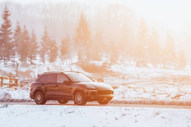 Karla kaplı otoyolda giden bir SUV. Kış lastikleri ve iyi bir araba aküsü..